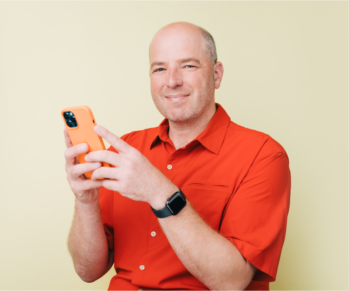 Russ sitting with his phone.